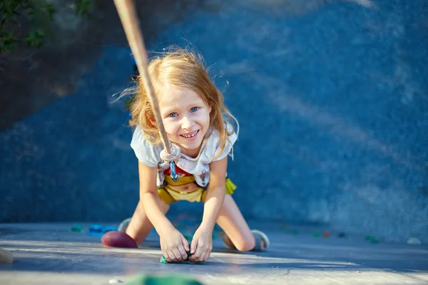 Little girl in  rock climbing gym