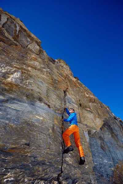 Climber climbing up a cliff — Stock Photo, Image