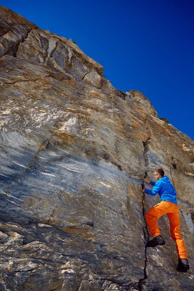 Climber climbing up a cliff — Stock Photo, Image