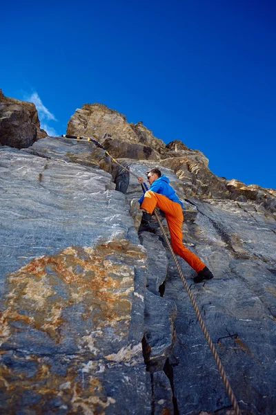 Climber climbing up a cliff — Stock Photo, Image