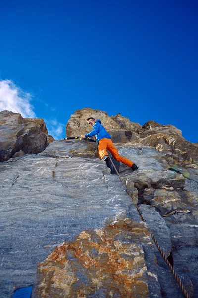 Climber climbing up a cliff — Stock Photo, Image