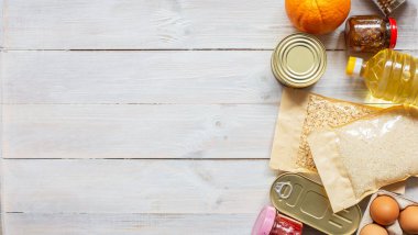 Tahta arka planda fotokopi alanı olan bir bağış yemeği. Düz yatıyordu. Model yap. Pirinç, konserve, yulaf gevreği, yumurta, reçel, yağ. Yiyecek bağışları ya da yemek servisi konsepti. Karantina sırasında online alışveriş.