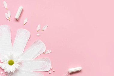 Adet pedleri ve pembe çiçekli tamponlar. Kavramsal kadın kritik günleri, adet döngüsünü, adet menopozunun durdurulmasını, hijyen, koruma