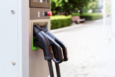 Elektrikli araçları şarj etmek için iki silahlı panel. Güneşli bir günde şehir caddesindeki şarj istasyonu. Modern ve çevre dostu bir ulaşım yöntemi. Kapat şunu.
