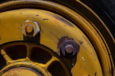 Metal levha, garaj parçası, sürgülü, tekerlek diski, fındık, vida, pas, eski boya ve metal aşınma izleri, çatlaklar.