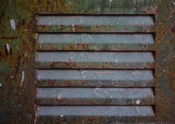 生锈的金属格栅 涂上油漆 从老年开始剥落 工业设施的进气口通风孔 一个电盾 一个开着的门 — 图库照片