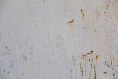 Sert bir duvarda ya da zeminde, boya pul pul dökülür. Aşınma ve paslanma. Eski harap olmuş duvar.