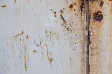 Sert bir duvarda ya da zeminde, boya pul pul dökülür. Aşınma ve paslanma. Eski harap olmuş duvar.