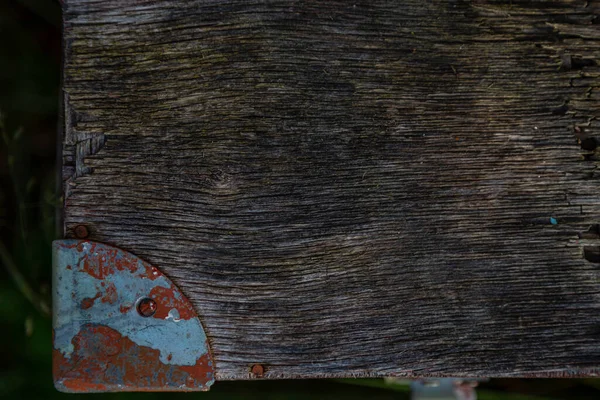 Wooden surface of the box, rusty metal parts, painted with paint and peeled off from old age, holes, nails in the base, an opening door. Screensaver background — Stock Image Wooden Surface Box Rusty Metal Parts Painted Paint Peeled Old Stock Picture