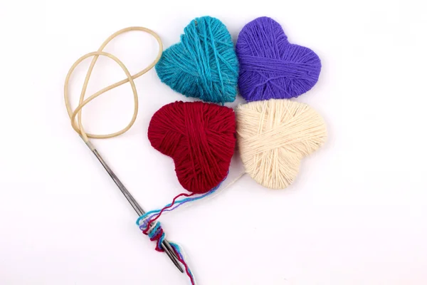 Heart wool yarn in coils with knitting needles — Stock Photo, Image