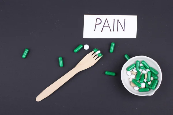 Pastillas con vaso de agua para beber las pastillas sobre fondo negro oscuro. Dolor. — Foto de Stock