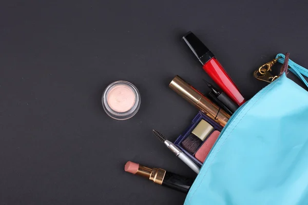 Hermosa bolsa de maquillaje con cosméticos sobre fondo negro —  Fotos de Stock