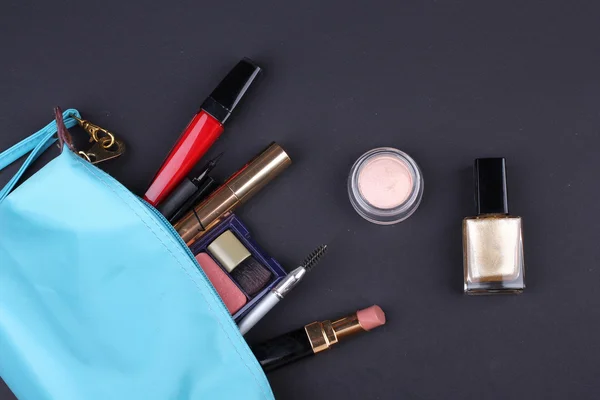 Bella borsa trucco con cosmetici su sfondo nero — Foto Stock