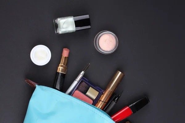 Hermosa bolsa de maquillaje con cosméticos sobre fondo negro —  Fotos de Stock