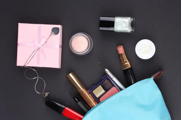 Bolsa de maquiagem bonita com cosméticos no fundo preto — Fotografia de Stock