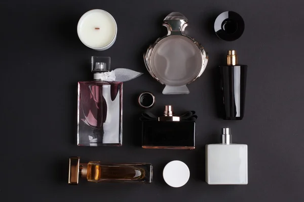 Différents flacons de parfum sur fond noir — Photo