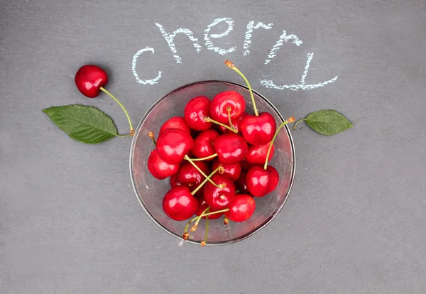 Fresh cherries on black chalkboard — Stock Photo, Image