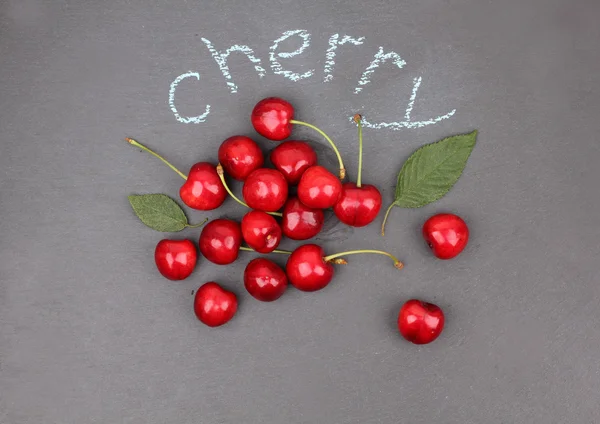 Fresh cherries on black chalkboard — Stock Photo, Image