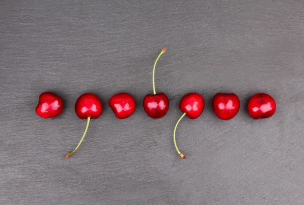 Fresh cherries on black chalkboard — Stock Photo, Image