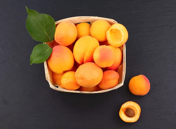 Абрикосы. Группа собранных абрикосов на корзине, вид сверху, фон на доске . — стоковое фото