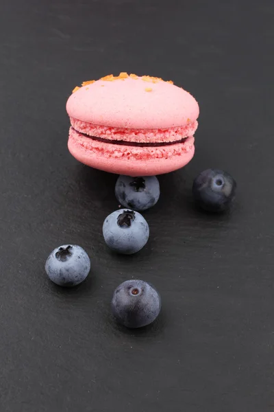 Close up of pink blueberry macaroons on blackboard — Stock Photo, Image