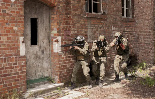 Three soldiers in full uniform stormed the building — Stock Photo, Image