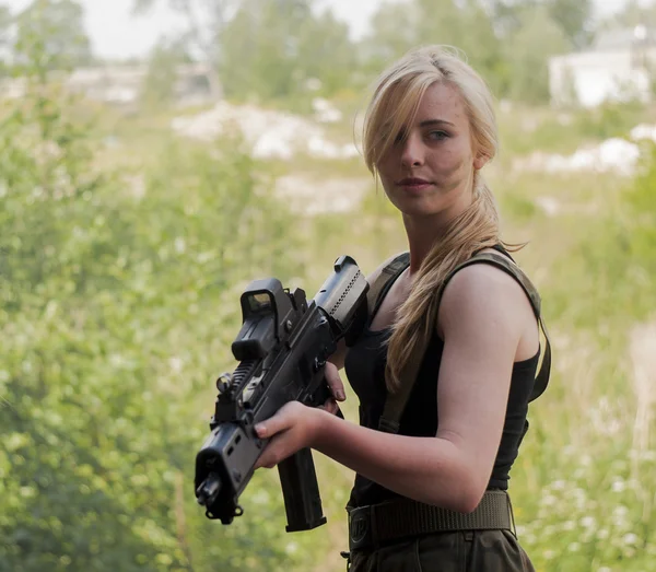 Mooie sexy blonde vrouw houden leger wapen — Stockfoto