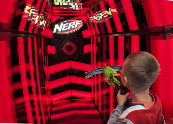 Jovem jogando arma de brinquedo Nerf — Fotografia de Stock