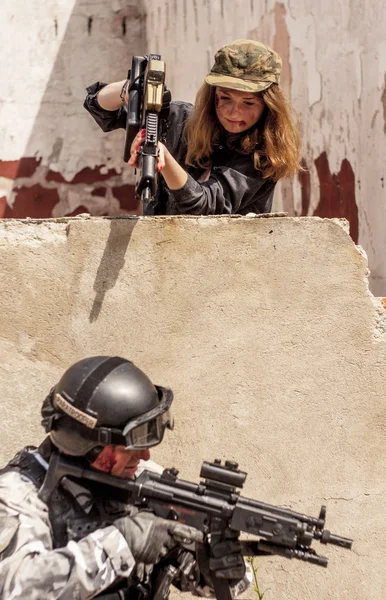 Mujer con arma para apuntar al soldado — Foto de Stock