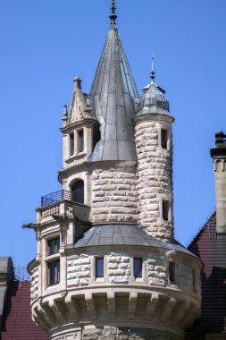 Kale kulesi taştan yapılmıştır ve levha metalle kaplıdır. Arka plan olarak mükemmel mavi gökyüzü.