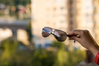 Moda kedisi gözlüklü kadınlar için güneş gözlüğü mankeni yaz günü kapalı çekimde el ele tutuşuyor. Seçici odak 