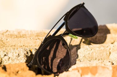 Bir yaz günü şehir merkezinde yakın çekim yapan kadınlar için moda siyah güneş gözlüğü modeli. Seçici odak 