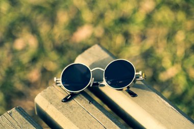 Siyah lensli Steampunk güneş gözlüğü modeli bir yaz günü yakın plan çekimde dışarıda çekiliyor. Seçici Odaklanma