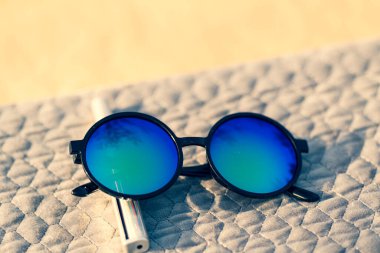 Güneşli bir günde, açık havada büyük mavi mercekli güneş gözlükleri fırlatılır. Seçici Odaklanma
