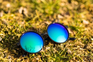 Güneşli bir günde, açık havada büyük mavi mercekli güneş gözlükleri fırlatılır. Seçici Odaklanma