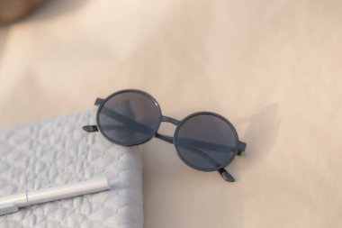 Büyük siyah mercekli güneş gözlükleri bir yaz günü yakın planda dışarıda çekiliyor. Seçici Odaklanma