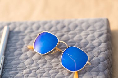 Güneşli bir günde mavi lensli klasik güneş gözlüğü modeli dışarıda çekim yapıyor. Seçici odak