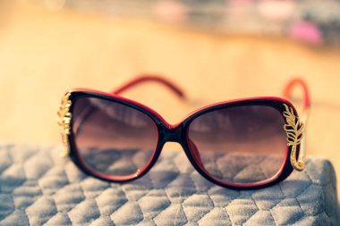 Güneş gözlüğü kırmızı modeli. Özel tasarım çekimleri olan kadınlar için. Bir yaz günü dışarıda. Seçici odak 