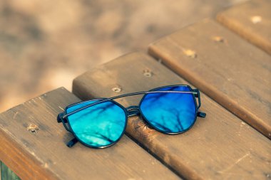 Mavi lensli ve siyah çerçeveli özel güneş gözlüğü mankeni yaz günü bayanlar için. Seçici odak 