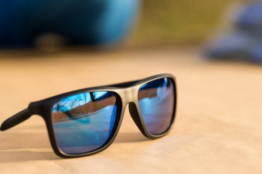 Kapanış gününde dışarıda mavi lensli ve siyah çerçeveli klasik güneş gözlüğü. Seçici odak