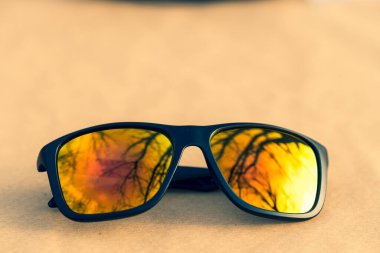 Altın lensli klasik güneş gözlüğü tasarımı güneşli bir günde açık havada çekiliyor. Seçici odak