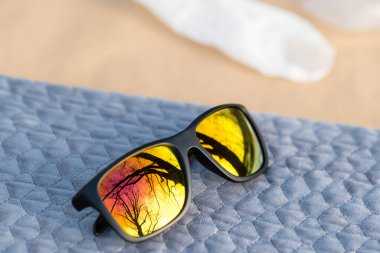 Altın lensli klasik güneş gözlüğü tasarımı güneşli bir günde açık havada çekiliyor. Seçici odak