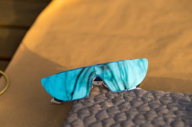 Özel tasarım mavi lensli güneş gözlükleri bir yaz günü yakın planda dışarıda çekiliyor. Seçici Odaklanma.