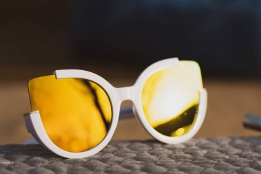 Kedi gözü güneş gözlüğü kadınlar için özel bir model. Altın lensler ve beyaz çerçeveler. Kapalı bir yaz gününde dışarıda çekim yapıyorlar. Seçici odak 