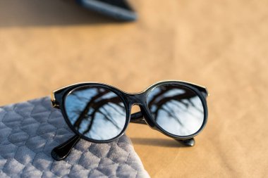 Güneşli bir günde dışarıda büyük yuvarlak gümüş lensleri ve siyah çerçeveli çekimleri olan bayanlar için moda kedi gözü güneş gözlüğü modeli. Seçici odak 