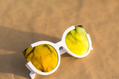 Kedi gözü güneş gözlüğü kadınlar için özel bir model. Altın lensler ve beyaz çerçeveler. Kapalı bir yaz gününde dışarıda çekim yapıyorlar. Seçici odak 