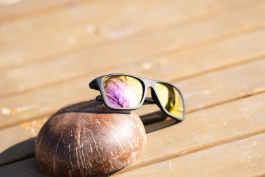 Renkli lensli klasik güneş gözlüğü spor modeli bir yaz günü yakın plan çekiminde dışarıda çekiliyor. Seçici odak