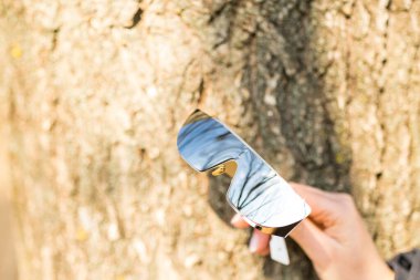 Gümüş lensli özel tasarım güneş gözlükleri bir yaz günü yakın planda dışarıda çekiliyor. Seçici Odaklanma.