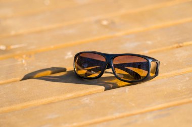 Sarı lensli güneş gözlükleri araba sürmek için özel. Bir yaz günü dışarıda yakın çekim yap.