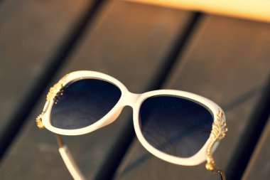 Güneş gözlüklü beyaz model özel tasarım çekimleri olan kadınlar için bir yaz günü dışarıda. Seçici odak 